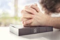 Hands folded in prayer on a Holy Bible in church, faith, spirtuality and religion Royalty Free Stock Photo