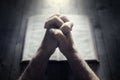 Hands folded in prayer on a Holy Bible in church, faith, spirtuality and religion Royalty Free Stock Photo