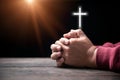 Hands folded in prayer on Holy Bible with cross in church concept for faith, spirituality and religion, Man praying on holy bible Royalty Free Stock Photo