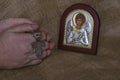 Hands folded in prayer with a silver cross in front of the icon of the Archang Royalty Free Stock Photo