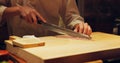 Hands, food and chef cutting sushi in restaurant for traditional Japanese cuisine or dish closeup. Kitchen, cooking Royalty Free Stock Photo