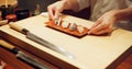 Hands, food and chef serving sushi in restaurant for traditional Japanese cuisine or dish closeup. Kitchen, cooking or Royalty Free Stock Photo