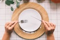 Hands with fork and knife, white plate on table. Royalty Free Stock Photo