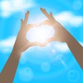 Hands in the form of heart on the background of blue sunny sky. Royalty Free Stock Photo