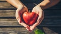 Hands forming heart around apple