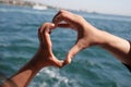 Hands forming a heart shape near the waterfront Royalty Free Stock Photo