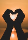 Hands forming a heart shape with sunset silhouette Royalty Free Stock Photo
