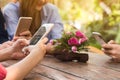 Hands of four teenagers use smartphone together in cafe