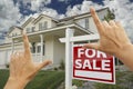 Hands Framing Real Estate Sign and New House