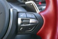 Hands free and media control buttons on the red steering wheel in black leather, modern car interior buttons on the steering wheel Royalty Free Stock Photo