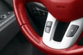 Hands free and media control buttons on the red steering wheel in black leather, modern car interior Royalty Free Stock Photo