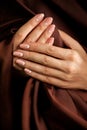 Hands with french-style manicure wrapped with silk