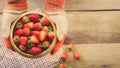 Hands with fresh strawberries in bowl