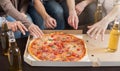 Hands of friends taking slices of tasty pizza