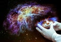 The hands of the future scientist in gloves hold a torch and create a new galaxy.