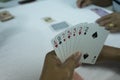 Hands of gambler playing card in rummy game. Close up card in ha