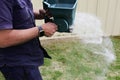 Hands of a gardener spreading fertilizer on grass lawn