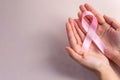 Hands gently holding a pink ribbon, symbolizing support and awareness for breast cancer Royalty Free Stock Photo