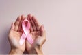 Hands gently holding a pink ribbon, symbolizing support and awareness for breast cancer Royalty Free Stock Photo