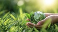 The hands gently holding a transparent globe surrounded by vibrant green leaves. AI generated image Royalty Free Stock Photo