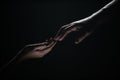 Hands gesturing on black background. Giving a helping hand. Support and help, salvation. Hands of two people at the time Royalty Free Stock Photo