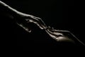Hands gesturing on black background. Giving a helping hand. Support and help, salvation. Hands of two people at the time Royalty Free Stock Photo