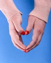 Hands of a girl in a beige sweater with a red manicure on her nails Royalty Free Stock Photo