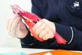 Hands of girl cutting flower from red paper for crafts Royalty Free Stock Photo
