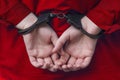 Hands of the girl in handcuffs. red clothes. Royalty Free Stock Photo