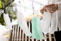 Hands of girl is hanging a mask outdoor on laundry day,round clothes hanger with drying masks,wash and clean for reuse during the Royalty Free Stock Photo