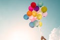 Hands of girl holding multicolored balloons