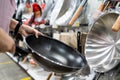 Hands of girl holding a new pan,choosing black teflon frying pan,asian customer deciding to buy non-stick frying pan for cooking