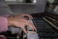 Hands of a girl on piano keyboard. Teenage girl learns to play the piano