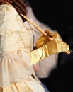 hands of girl with silky yellow gloves holding the handle of the umbrella dressed in nineteenth-century dress