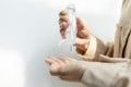 Hands of girl squeezing the hand sanitizer on her palm or pour skin care lotion from small portable plastic bottle,female people