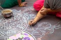 Hands of girls making rangoli - indian mandala. Indian tourism. Indian traditional culture, art and religion. decorative