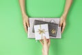 Hands give and take presents boxes over light green background. Christmas, New Year, holidays, birthday concept Royalty Free Stock Photo