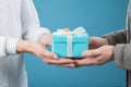 Hands giving and receiving present. Male and female hands holding gift box on blurred background Royalty Free Stock Photo