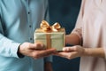 Hands giving and receiving present. Male and female hands holding gift box on blurred background Royalty Free Stock Photo