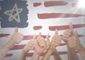 Hands giving thumbs up against hand drawn american flag and white wall with flare Royalty Free Stock Photo