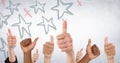 Hands giving thumbs up against white wall with red and blue hand drawn star pattern Royalty Free Stock Photo