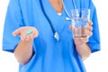 Hands, glass of water and pills, nurse and healthcare in studio, supplements or vitamins on white background. Health Royalty Free Stock Photo