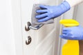 Hands in gloves disinfecting door handle with rag and spray detergent Royalty Free Stock Photo