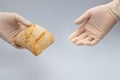 Hands with gloves and giving fresh bread