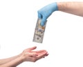 Hand in medical gloves giving money over white background