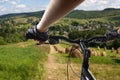 Hands in gloves holding handlebar of a bicycle. Mountain Bike cyclist riding single track. Healthy lifestyle active athlete doing Royalty Free Stock Photo