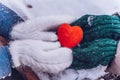 Hands in gloves holding heart closeup on winter snow background. Toned. Royalty Free Stock Photo