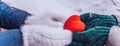 Hands in gloves holding heart closeup on winter snow background. Toned. Royalty Free Stock Photo