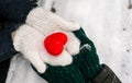 Hands in gloves holding heart closeup on winter snow background. Toned. Royalty Free Stock Photo