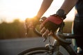 Hands in gloves holding road bicycle handlebar. Sports and outdoor activities concept